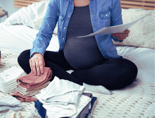 mulher grávida organizando os itens da lista de enxoval do bebê