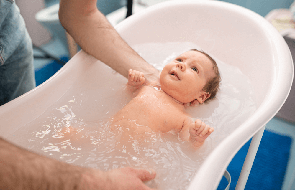 bebê sendo banhado em banheira de bebê