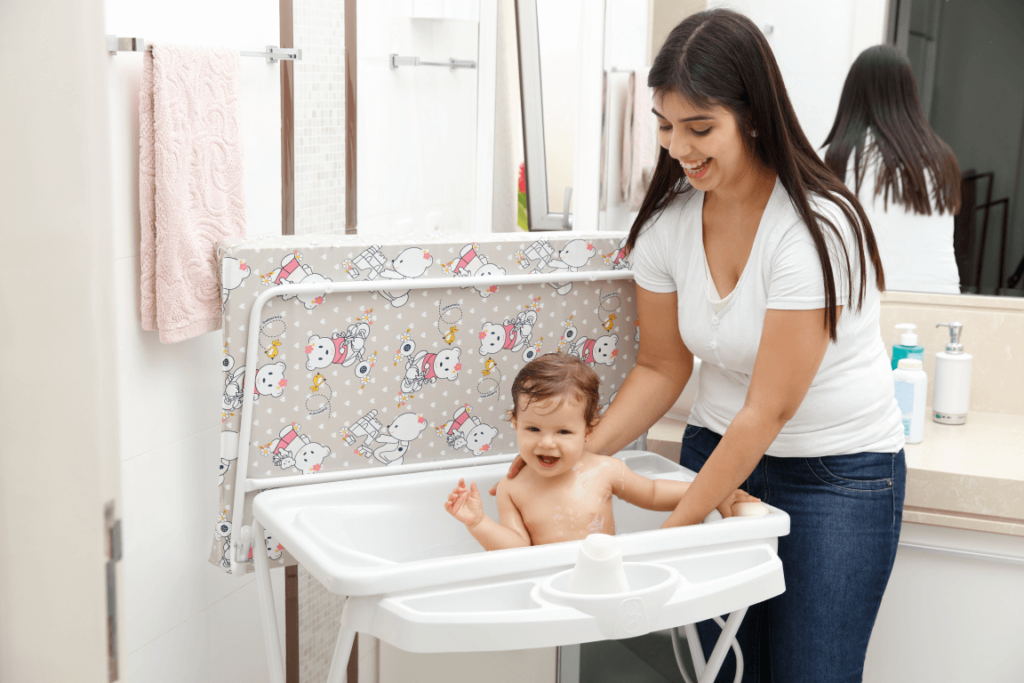 criança sentada em uma banheira de bebê com trocador para o banho