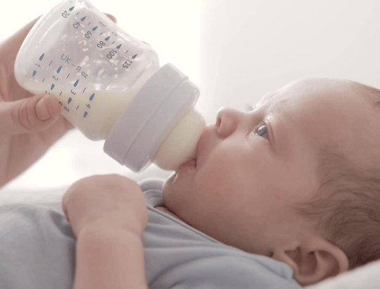 bebe tomando mamadeira com leite NAN