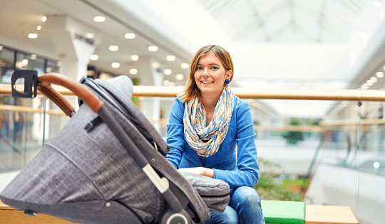 mulher com carrinho de bebê Chicco passeando no shopping