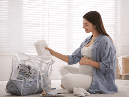mulher organizando mala maternidade com itens para lista de enxoval de bebê