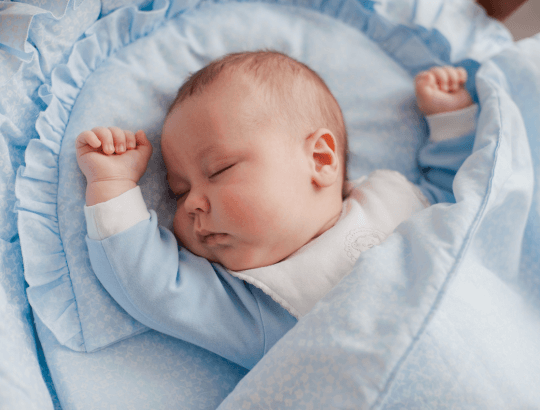 Bebê deitado sobreTravesseiro Antirrefluxo, na cor azul