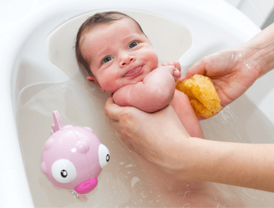 Bebê tomando banho em uma banheira retrátil para bebê