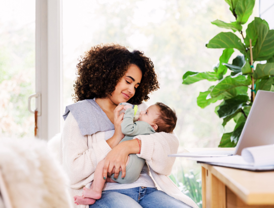 mulher alimentando o seu bebê com fórmula infantil aptamil