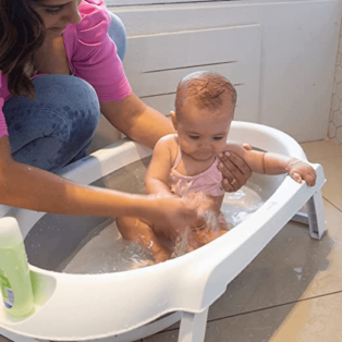 mulher dando banho em bebê na Banheira retrátil para bebê Safety 1st Smile