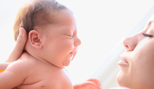 mulher segurando um bebê durante o banho de sol em recém-nascido