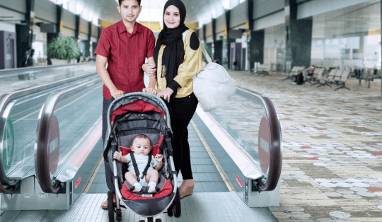 casal com bebê em um carrinho de passeio no aeroporto