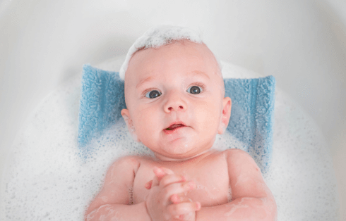 bebê sendo banhado em uma banheira com almofada para banheira de bebÊ