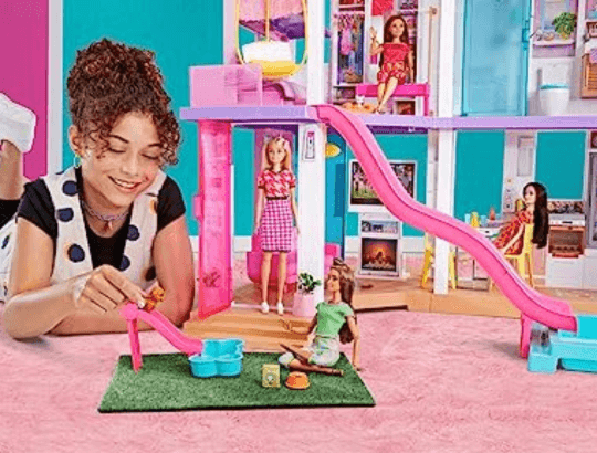 criança brincando com boneca barbie e acessórios da marca