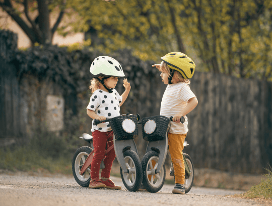 duas crianças se divertindo com as melhores bicicletas de equilíbrio infantil