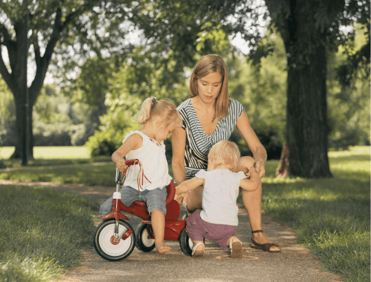 mãe passeando com criança em um triciclos infantis