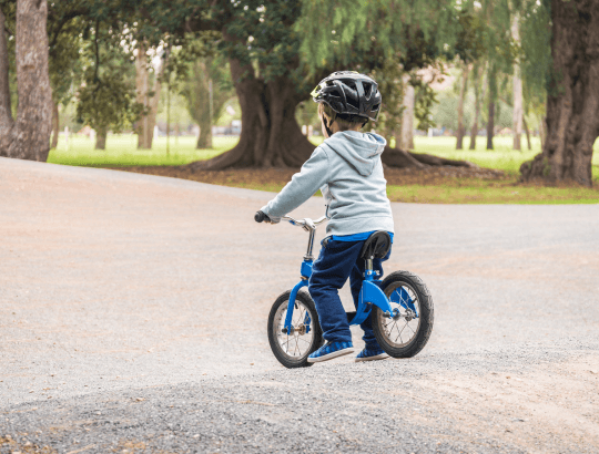 menino andando em bicicleta de equilíbrio infantil em um parque