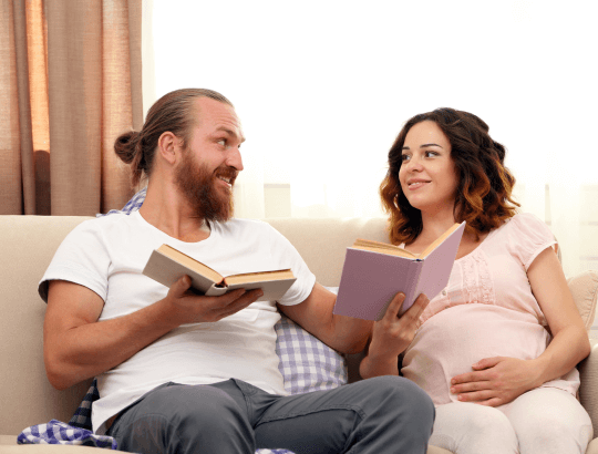 Casal lendo livros sobre maternidade