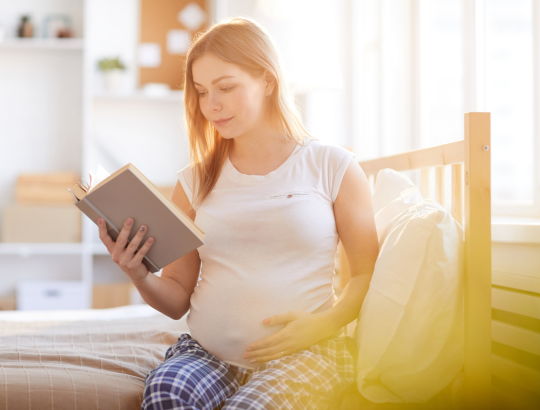 Mulher grávida conhecendo os Benefícios da Leitura de Livros sobre Maternidade