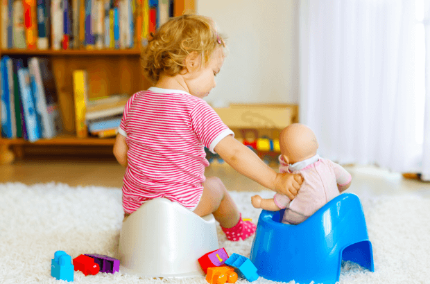 bebê menina sentada no melhor troninho infantil para a sua idade enquanto brinca com uma boneca