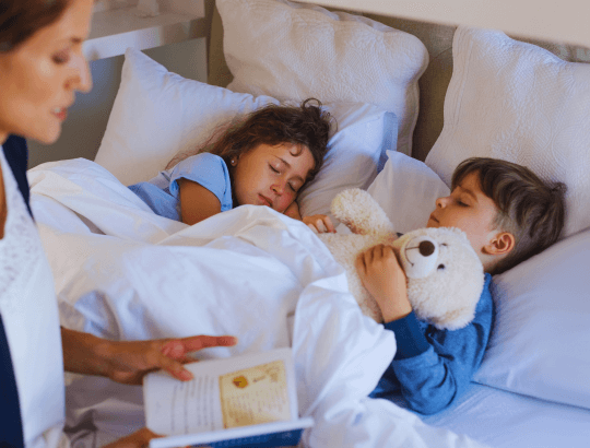 mulher lendo histórias infantis para crianças antes de dormir
